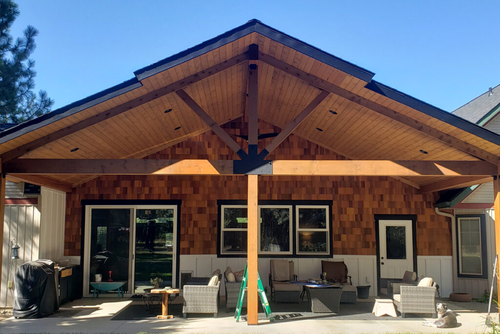 Post Falls covered patio builder project with heavy timber beams and exposed wood ceiling